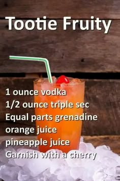 an orange drink with a cherry on the top and ice surrounding it, in front of a wooden background