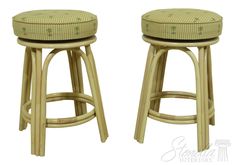 two wicker stools with green upholstered cushions on each one and the other side