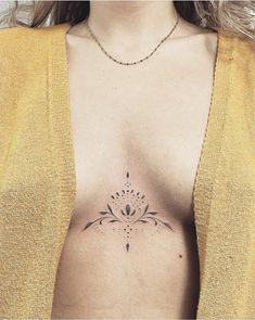 a woman's chest with a flower tattoo on the left side of her stomach