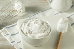 a bowl of whipped cream next to a spoon