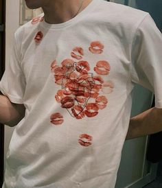 a man wearing a white t - shirt with red lipstick on it