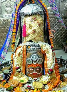 an elaborately decorated statue with food on the ground