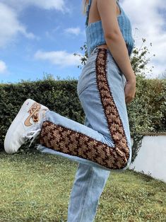 a woman carrying a snake skin handbag in her right leg, with one foot on the ground