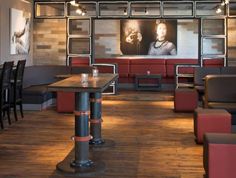 the interior of a restaurant with red and black booths, wooden tables, and pictures on the wall