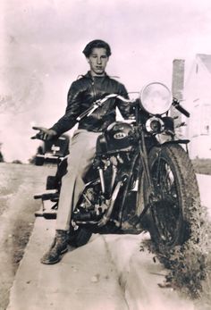 an old black and white photo of a man on a motorcycle