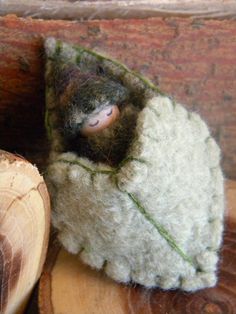 a close up of a stuffed animal in a piece of wood on top of a table