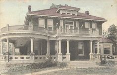 an old photo of a large house with porches