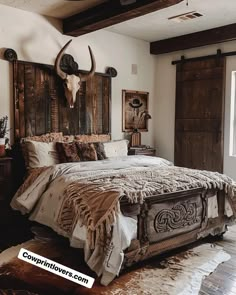 a rustic bedroom with an old wooden headboard and cow skull on the wall above the bed