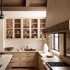 a kitchen filled with lots of wooden cabinets and counter top space next to a window