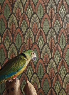 a parrot sitting on top of a piece of wood in front of a wallpaper