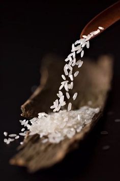 white rice being poured onto a wooden spoon