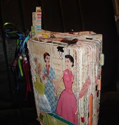 an old fashion book is adorned with colorful ribbons and ribbon clips, which are attached to the back of a car seat