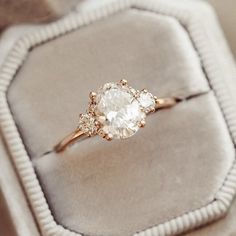 an engagement ring sitting on top of a velvet cushion in a box with its lid open