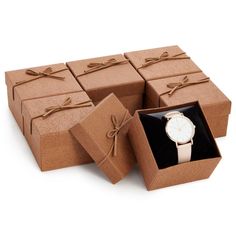 a watch in a gift box with its lid open and tied around the wristband