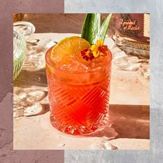 an orange drink in a glass with a flower on the rim and garnish