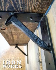 an iron work is attached to the side of a wooden structure with metal rivets