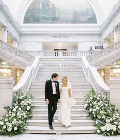 a bride and groom are standing on the stairs