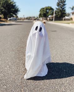 a white ghost sitting on the side of a road