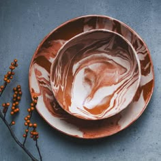 two brown and white plates sitting next to each other on top of a blue surface