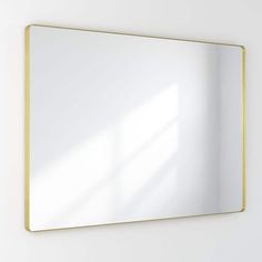 a mirror hanging on the wall next to a white wall with a yellow border around it