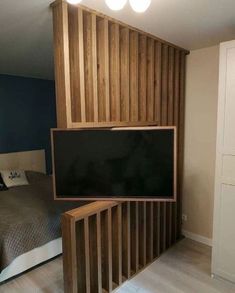 a bed room with a neatly made bed and a flat screen tv mounted to the wall