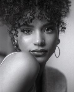 a black and white photo of a woman with curly hair