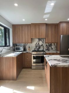 a kitchen with marble counter tops and wooden cabinets