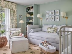 a baby's room with green walls and white furniture