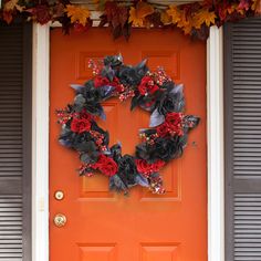 an orange front door with a wreath on it