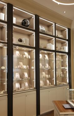 a room filled with lots of glass shelves covered in white hats and other items on display cases