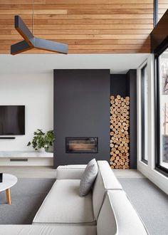 modern living room with white couches and wood paneled ceiling above the fire place