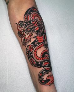 a man's arm with a dragon tattoo on the left side of his arm