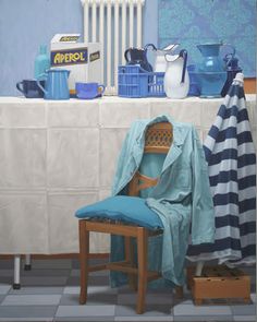 a blue chair sitting in front of a white table covered with towels and other items