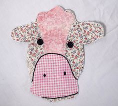 a patchwork cow head with pink and white flowers on it's face is shown