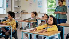 a group of children sitting at desks in a classroom