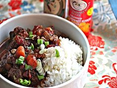 a bowl filled with rice, meat and veggies next to a can of beer