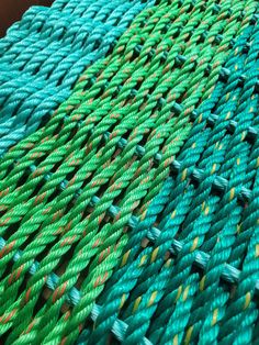 green and yellow braided rope on top of each other in close up view to the side