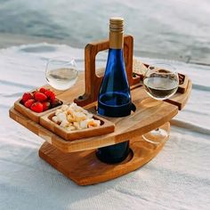 a wooden tray with wine, cheese and strawberries on it