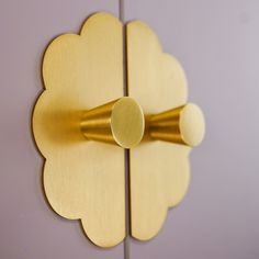 a gold flower shaped door handle on a purple wall