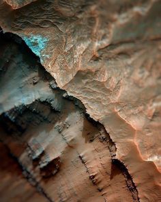 a close up view of the surface of a rock formation with blue light coming from it