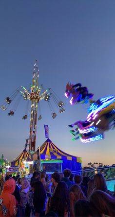 an amusement park at night filled with people