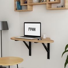 a laptop computer sitting on top of a desk next to a wooden shelf filled with books