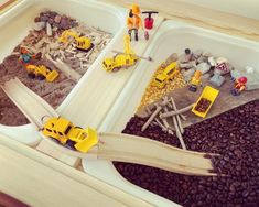 a toy train set sitting on top of a table filled with dirt and construction vehicles