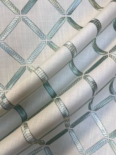 a close up view of a white fabric with blue and silver designs