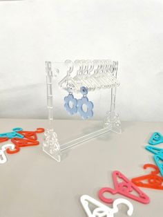 several pairs of scissors are sitting in front of some plastic hangers on a table