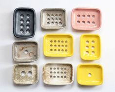 nine different colored ceramic trays with holes in the middle one is yellow, white, and blue