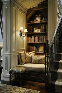 a living room filled with lots of furniture and bookshelves next to a stair case