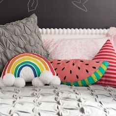 a bed topped with lots of pillows next to a chalkboard