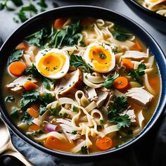 a bowl of soup with noodles, carrots and hard boiled eggs