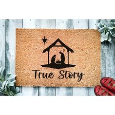 a door mat that says true story with a nativity scene on it and red shoes next to it